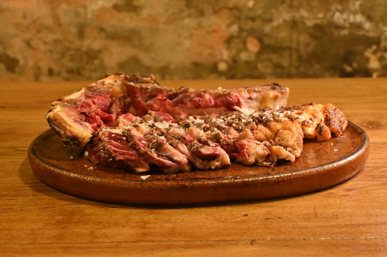 Txuleta a la brasa cortada sobre tabla de madera